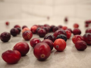 Freshly harvested cranberries scattered artistically on a smooth surface invite culinary creativity and seasonal delight