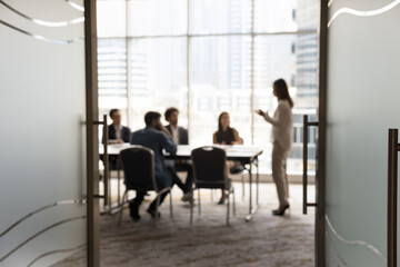 Silhouettes of businesspeople gathered in conference room for negotiation or seminar event, female...