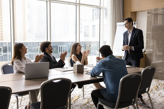 Inspired motivated business team applauding to Arabian male coach after successful presentation, clap hands, gesture of respect and acknowledgement. Motivation, giving positive feedback, recognition