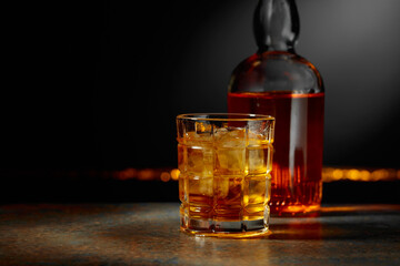 Whiskey with ice on a dark background.
