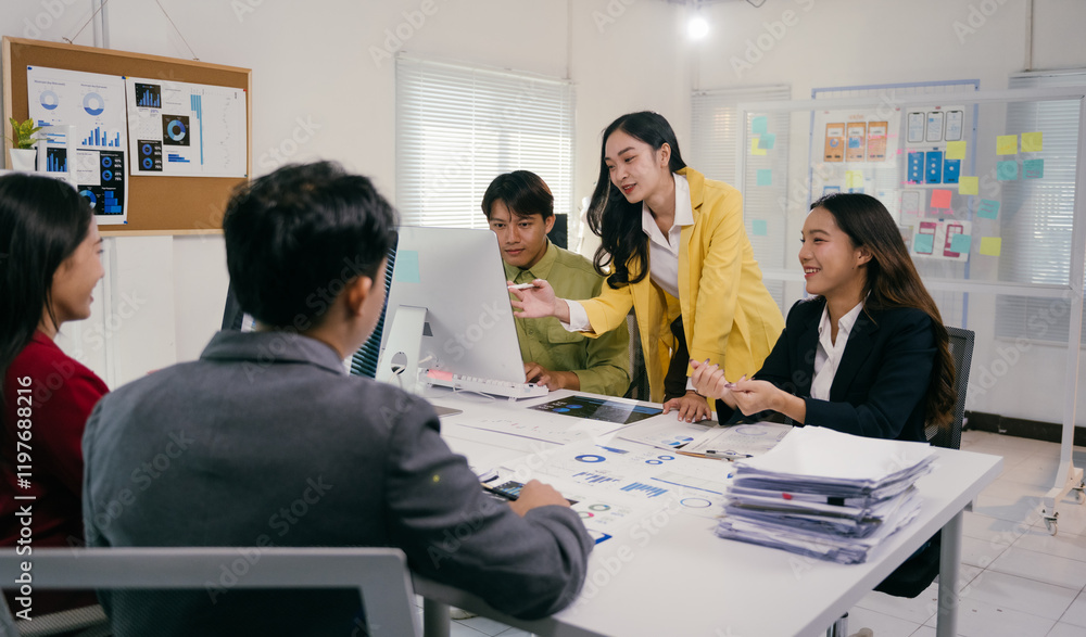 Poster Group of young asian businesspeople discussing and analyzing data on computer screen during a productive meeting in modern office, demonstrating teamwork and collaboration