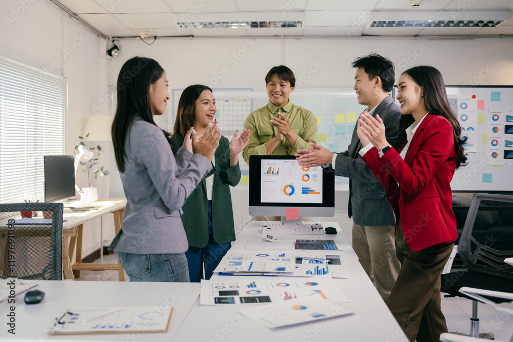 Aufkleber Group of asian marketing professionals clapping hands celebrating successful project while standing near computer with charts and graphs in modern office