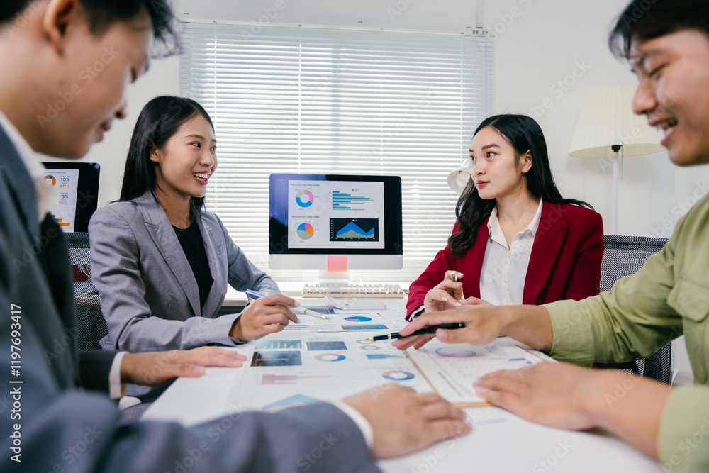 Poster Asian businesspeople discussing and analyzing charts and statistics displayed on a computer screen and printed documents, working together in the office for a successful business strategy