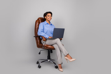 Full length photo of lovely young business lady sit armchair hold netbook dressed stylish...