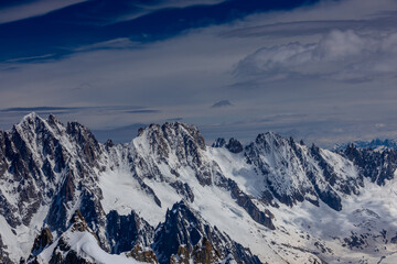 Obraz premium View of snow mountain glaciers at the high altitude in the Alps. Stunning mountain landscape with high snow peaks and summits of Mont Blanc mountain range from Aiguille du Midi summit