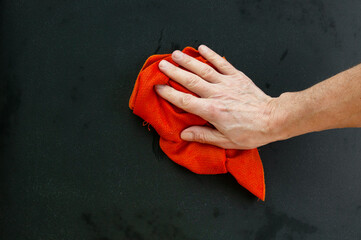 Hand with wet rag erases chalkboard close up
