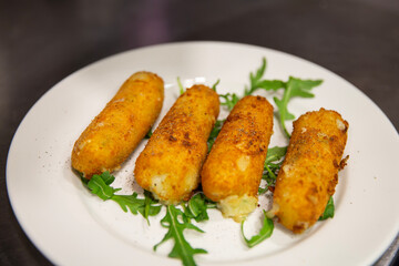 Plato de croquetas de queso y rúcula