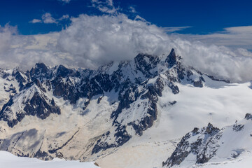 Fototapeta premium View of snow mountain glaciers at the high altitude in the Alps. Stunning mountain landscape with high snow peaks and summits of Mont Blanc mountain range from Aiguille du Midi summit