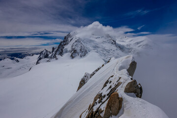 View of snow mountain glaciers at the high altitude in the Alps. Stunning mountain landscape with high snow peaks and summits of Mont Blanc mountain range from Aiguille du Midi summit