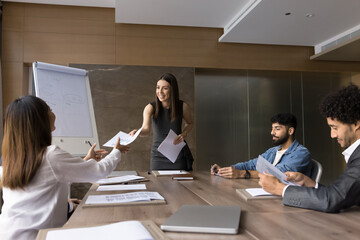 Team leader hold formal meeting share handout material to diverse colleagues during briefing event....