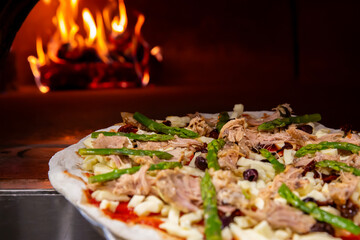 Pizza entrando o saliendo de horno de leña