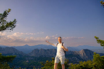 Naklejka premium Traveling lifestyle excursion day concept. Smiling hiker man with backpack on mountain landscape Antalya cable car Turkey.
