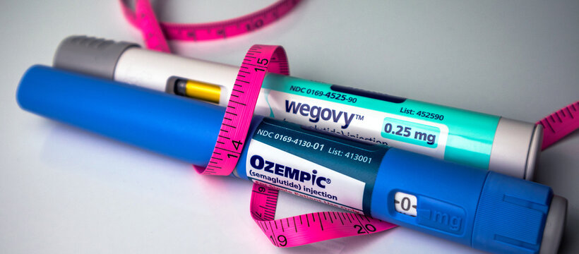 Ozempic and Wegovy semaglutide pens with pink tape measure 