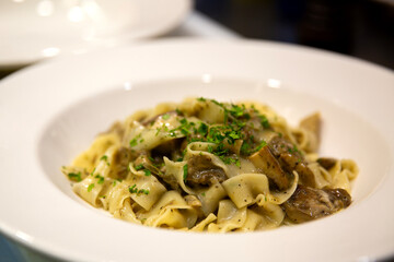 Plato de espaguetis fettuccini con setas y perejil