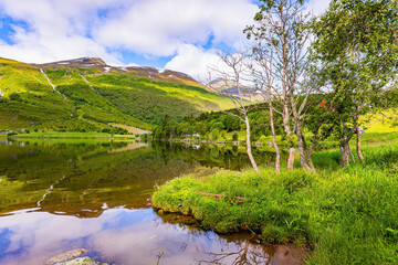 The water reflects lush clouds