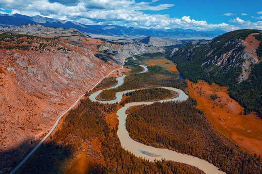 Beautiful aerial landscape winding river meander in mountains with forest trees with sunlight, Altai Russia, top view