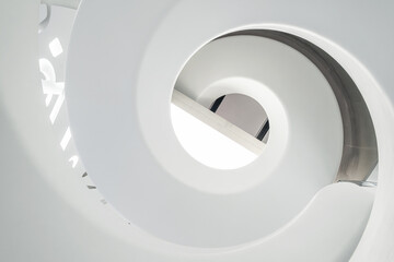 Abstract view of white spiral staircase with smooth curves and geometric patterns in The Museum of the Future, bottom view. Modern interior design in Dubai city, United Arab Emirates. View from below