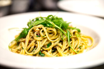 Plato de pasta italiana con anchoas y rúcula