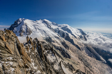 Obraz premium View of snow mountain glaciers at the high altitude in the Alps. Stunning mountain landscape with high snow peaks and summits of Mont Blanc mountain range from Aiguille du Midi summit