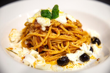 Plato de pasta italiana con mozzarella y aceitunas negras
