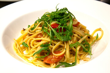 Plato de pasta italiana con tomates y rúcula
