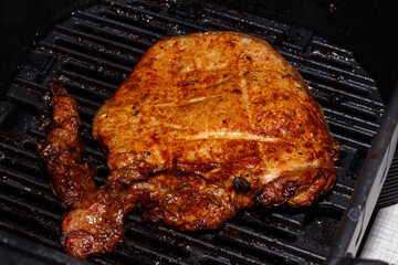 Pork steak is cooked in an air grill