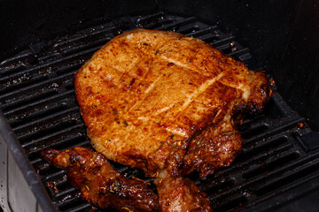 Pork steak is cooked in an air grill