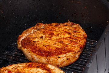Pork steak is cooked in an air grill