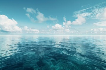 Tranquil ocean scene with calm water reflecting the cloudy sky on a beautiful sunny day