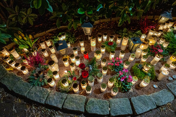 Grave candles in a cemetery at all saints eve.