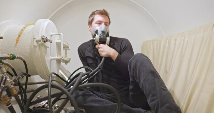 Man in hyperbaric chamber using BIBS mask closeup