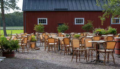 Empty chairs and tables at an outdoor cafe.
