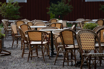 Empty chairs and tables at an outdoor cafe.