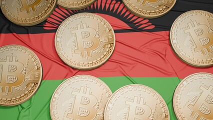 Several bitcoins are laid out on the flag of Malawi