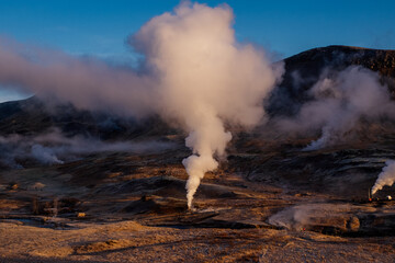 Aerial view of Hveragerdi, South Iceland, showcasing geothermal steam vents and rugged landscapes at dawn.