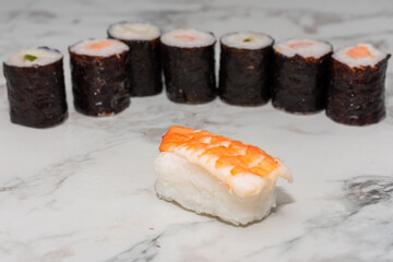 Plated Nigiri Ebi sushi at the center, surrounded by an assortment of colorful sushi varieties. The vibrant presentation highlights the textures and artistry of traditional Japanese cuisine