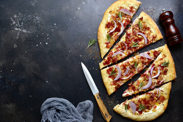 Tart flambe ( tarte flambee ) - onion pie with soft cheese and smoked bakon. Top view  with copy...
