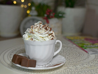 filiżanka czekolady z bitą śmietaną, biała filiżanka kawy z bitą śmietaną, a cup of chocolate with whipped cream, a white cup of coffee with whipped cream, hot chocolate topped with whipped cream