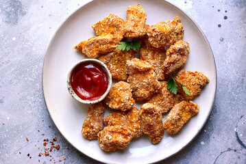 Fresh  homemade crispy chicken nuggets with ketchup.
