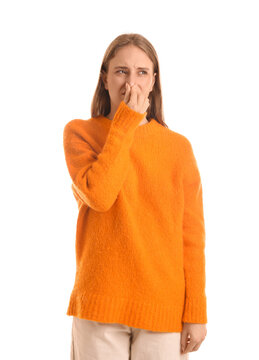 Young woman feeling disgusting smell on white background