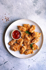 Fresh  homemade crispy chicken nuggets with ketchup.