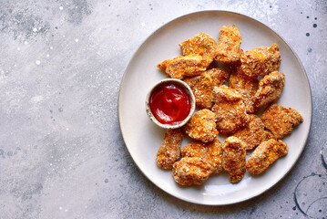 Fresh  homemade crispy chicken nuggets with ketchup.