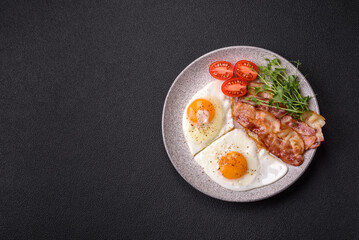 A hearty breakfast with fried eggs, bacon, tomatoes, microgreens