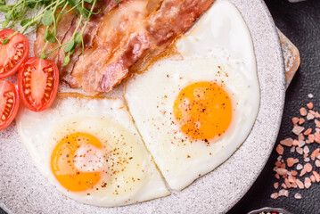 A hearty breakfast with fried eggs, bacon, tomatoes, microgreens