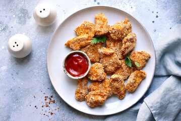 Fresh  homemade crispy chicken nuggets with ketchup.