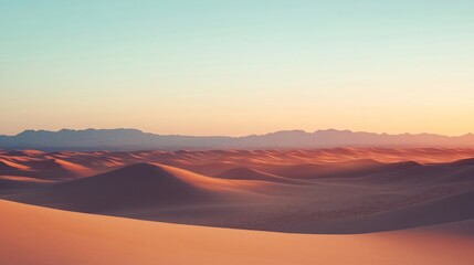 This image illustrates a peaceful desert landscape at sunset, characterized by rolling dunes of golden sand extending towards distant mountains under a gradient sky.