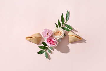 Composition with flowers, plant leaves and fortune cookies on color background