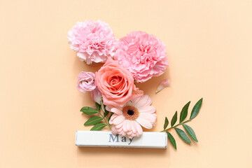 Composition with beautiful flowers and word MAY on color background
