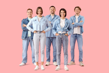 Group of young people in denim clothes on pink background