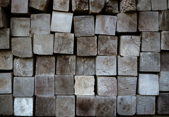 Stack of squared lumbers. Pile of wood in timber logs storage, A material for architectural and structural construction or industrial work for background and texture.
